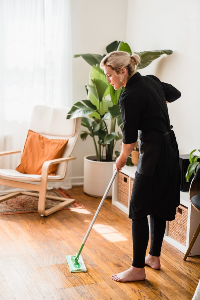 woman cleaning wood floor with mop